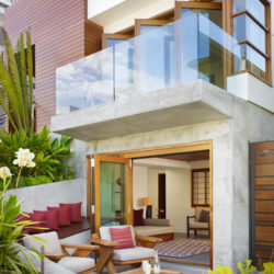 Beautiful-Tropical-House-With-white-stone-walls-wooden-door-sofa-pink-pillow-table-flower-decor-carpet-chair-lamp-design